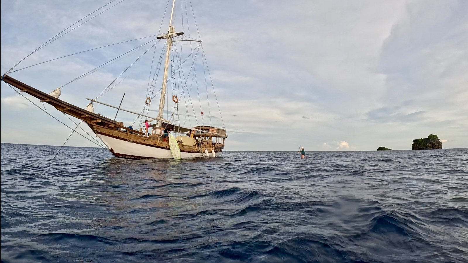 Дерев'яний liveaboard-вітрильник і мандрівниця на SUP-борді серед островів Раджа Ампат