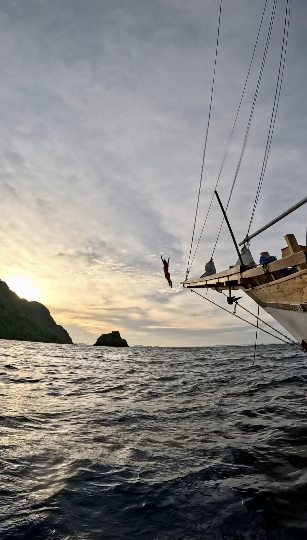 Стрибок з носа liveaboard у море на заході сонця біля островів Раджа Ампат